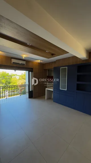 Sala de estar com paredes de madeira e acesso a uma área externa.