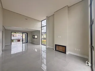 Esta é uma foto de uma sala de estar ampla com piso claro e paredes neutras.