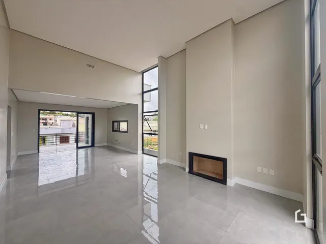 Esta é uma foto de uma sala de estar ampla com piso claro e paredes neutras.