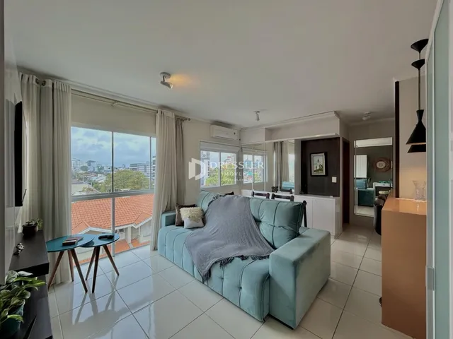 Sala de estar com sofá azul e piso de cerâmica clara.