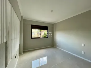 Ambiente interno de uma sala com piso de cerâmica e parede de painel.