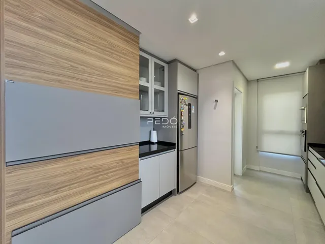 Cozinha moderna com armários e eletrodomésticos em aço inoxidável.
