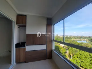 Vista interna de um ambiente com grande janela oferecendo uma paisagem verde.