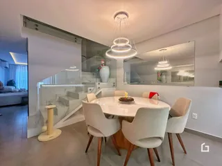 Imagem de uma sala de jantar moderna com mesa e cadeiras brancas.