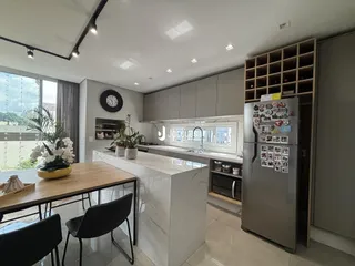 Imagem de uma sala de estar e cozinha moderna com ilha e armários.