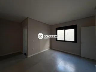Foto de um cômodo interno com paredes claras e uma grande janela.