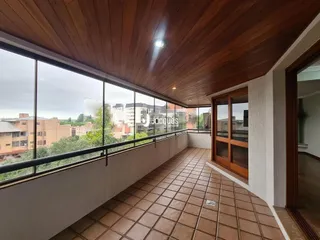 Vista de uma sala com piso de cerâmica e teto de madeira em Lajeado.