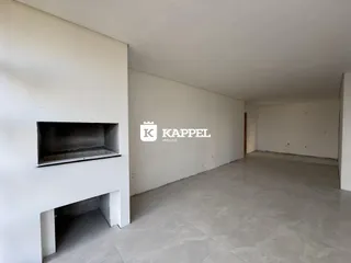 Ambiente interno amplo com paredes brancas e piso de cerâmica.