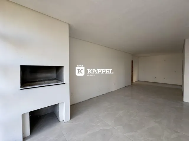 Ambiente interno amplo com paredes brancas e piso de cerâmica.