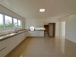 Cozinha moderna com bancadas e janelas amplas.