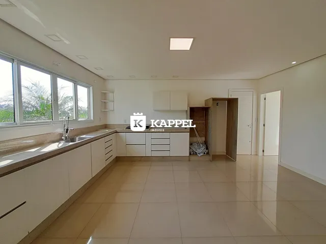 Cozinha moderna com bancadas e janelas amplas.