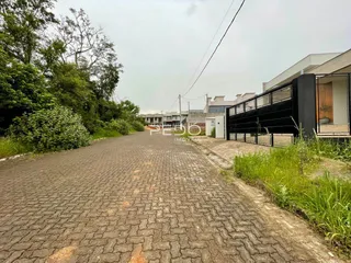 Vista da rua e da propriedade em Lajeado, Brasil, com vegetação lateral.