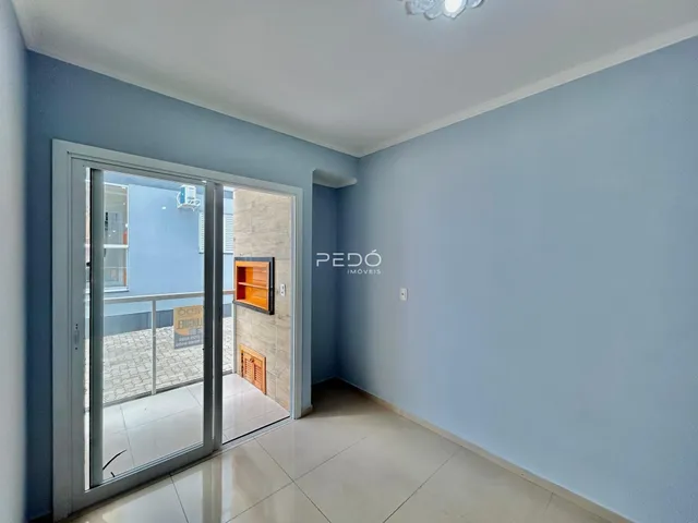 Interior de um ambiente com porta de vidro que dá acesso a uma área externa.