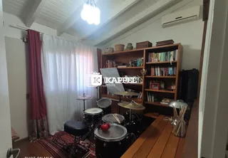 Sala de estar com estantes de livros e um kit de bateria.