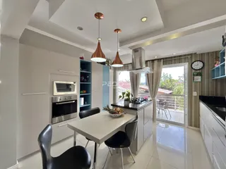 Vista de uma cozinha moderna com ilha e área de jantar em um imóvel no Brasil.