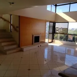 Ambiente interno com piso de cerâmica e escadaria em uma residência.