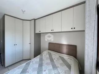 Quarto com armários embutidos e cama de cabeceira.