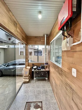 Hall de entrada com revestimento de madeira e piso cerâmico.