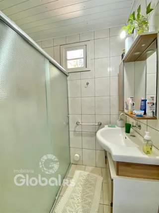 Foto de um banheiro com revestimento cerâmico claro.