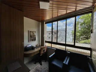 Sala de estar com grande janela e piso de madeira em Lajeado, Brasil.