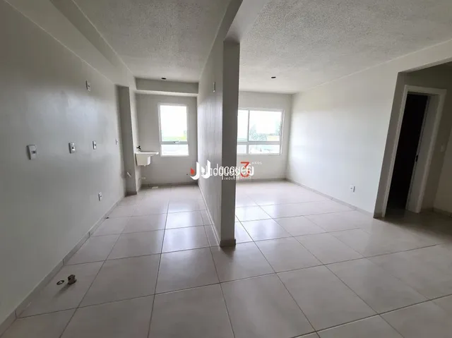 Corredor interno com piso de cerâmica e paredes brancas.