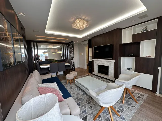 Sala de estar com sofá e lareira em um apartamento moderno.