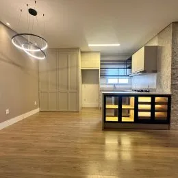 Sala de estar com piso de madeira e armário embutido na parede.
