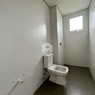 Foto de um banheiro com paredes brancas e piso escuro.