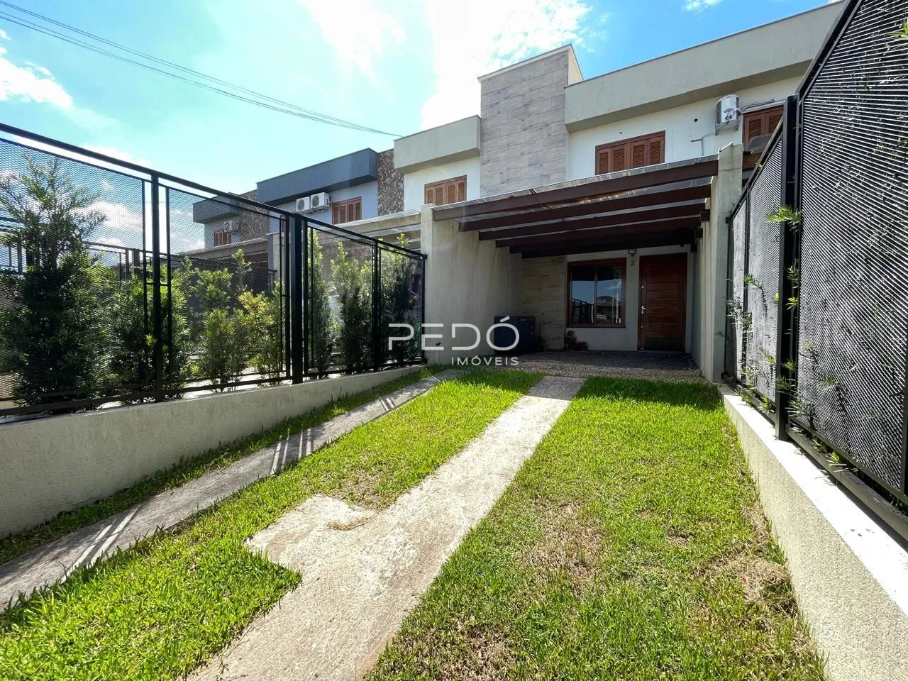 Vista da fachada de uma residência em Lajeado, Brasil, com jardim e cerca.