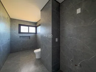 Hall de banheiro com piso de mármore cinza.