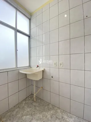 A foto mostra o interior de um banheiro com revestimento de azulejos brancos.