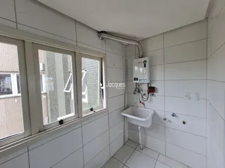 Banheiro com revestimento cerâmico branco nas paredes.