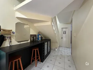 Vista de um corredor interno com piso de cerâmica e escadaria.