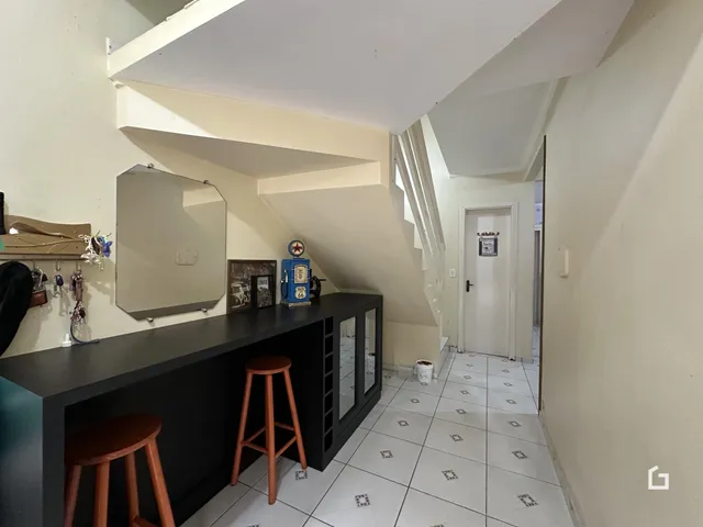 Vista de um corredor interno com piso de cerâmica e escadaria.