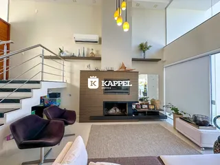 Foto de uma sala de estar com lareira e escadaria em um apartamento.