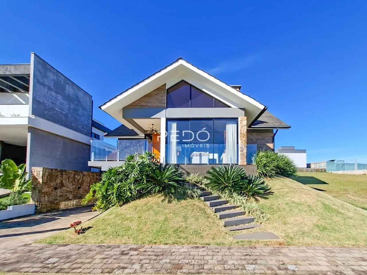 Fachada de uma casa moderna em Lajeado, Brasil, com jardim e paisagismo.