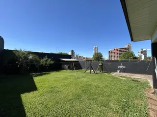 Vista externa de um jardim gramado com fundo de edifícios na Lajeado.