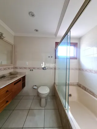 Foto de um banheiro com box de vidro e banheira.