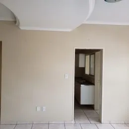 Foto de um corredor interno com porta aberta em uma residência.