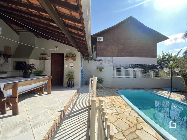 Vista da fachada de uma casa com piscina e área externa em Lajeado.
