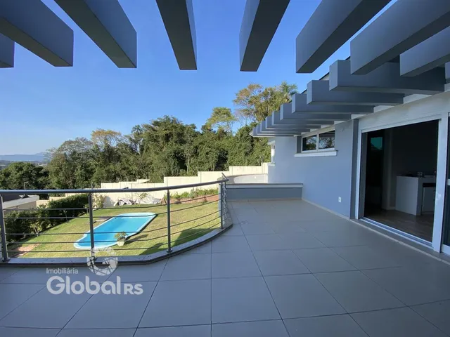 Vista do quintal com piscina e jardim de uma residência em Lajeado.
