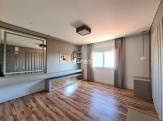 Ambiente interno com piso de madeira clara e paredes neutras.