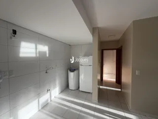 Hall de entrada com piso de cerâmica e paredes brancas.