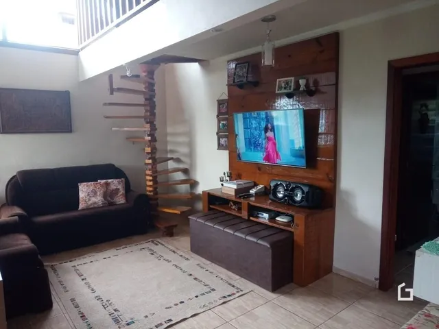 Sala de estar com sofá e painel de madeira em Lajeado, Brasil.