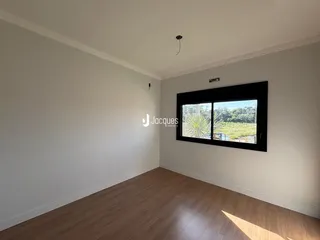 Sala de estar com piso de madeira e janela de grande porte.