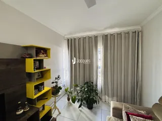 Ambiente interno com paredes brancas e cortinas cinzas em uma sala.