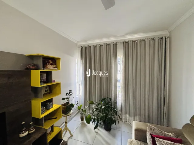 Ambiente interno com paredes brancas e cortinas cinzas em uma sala.