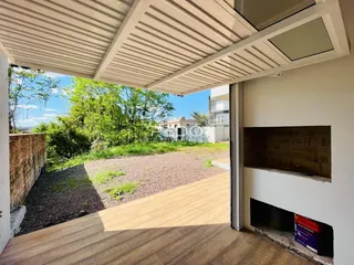 Vista da fachada com deck de madeira e área externa no lote.