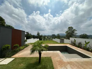 Vista externa de um jardim com piscina e paisagem no imóvel.
