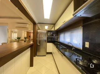 Vista de um corredor interno com armários e geladeira inoxidável.